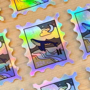 May include: A set of iridescent holographic stickers featuring a whale jumping out of the water with a crescent moon and clouds in the background. The stickers have a scalloped edge and say "52¢" in the bottom right corner.