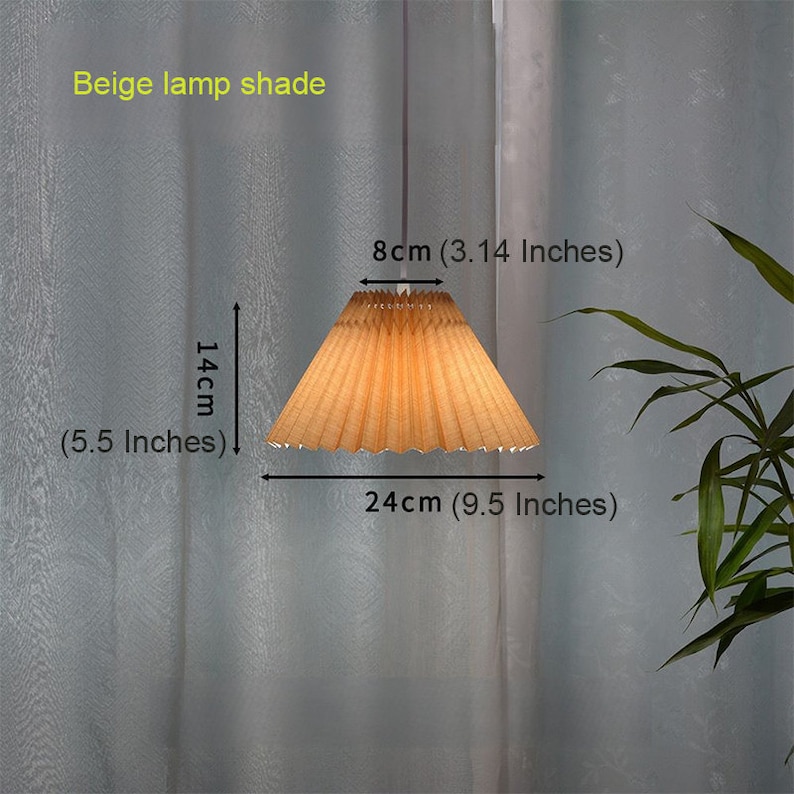 May include: Beige lamp shade with pleated fabric. The shade is 9.5 inches wide and 5.5 inches tall. The shade is 3.14 inches in diameter at the top.