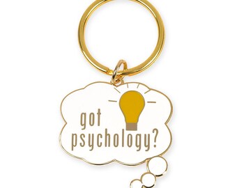 May include: Gold-colored keychain with a white thought bubble that says "got psychology?" with a lightbulb inside. The thought bubble has a gold-colored outline and a small gold-colored chain attached to the top.