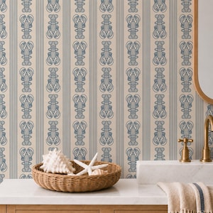 Puede incluir: Papel pintado con un patrón repetitivo de langostas azules y rayas verticales sobre un fondo beige. Una cesta tejida sobre una encimera blanca contiene conchas marinas y una estrella de mar. Tema costero o náutico.