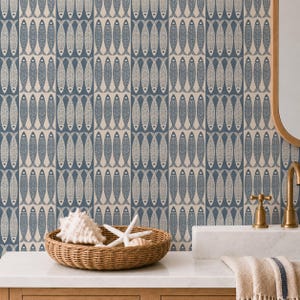 May include: A bathroom with blue and cream fish pattern wallpaper. A woven basket contains a seashell and starfish. A gold tap and mirror are visible, along with a white countertop and a beige towel.