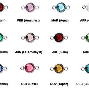 May include: A collection of twelve gemstone charms in various colors, each with a silver-tone loop on either side. Each charm is labeled with a month and gemstone name, including Siam, Amethyst, Aqua, Crystal, Emerald, Lt. Amethyst, Peridot, Sapphire, Rose, Topaz, and Blue Zircon.