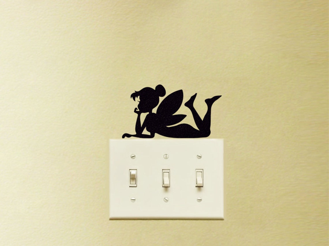 A wall decal of a fairy lying on the power switch