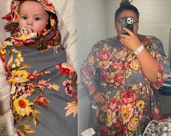 Può includere: Una vestaglia grigia a fiori con un involucro con cappuccio abbinato per un bambino. La vestaglia ha una cintura a fiocco e presenta una grande stampa floreale con fiori rosa, gialli e rossi.
