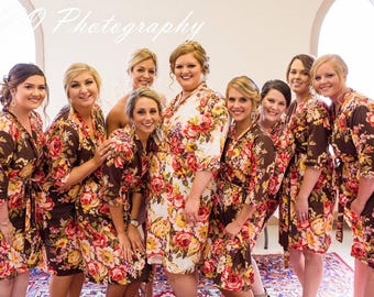 Può includere: Un gruppo di otto donne che indossano accappatoi con stampa floreale marrone. Gli accappatoi hanno maniche lunghe e una cintura da legare in vita. Le donne sorridono e guardano la fotocamera.