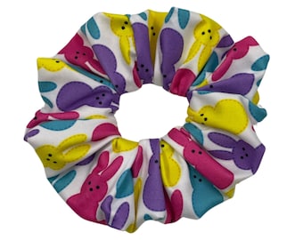 May include: A white scrunchie with a colourful pattern of yellow, pink, purple and blue bunny shapes.