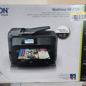 Könnte beinhalten: Ein schwarzer Epson WorkForce WF-7720 Wireless-Drucker mit einem farbigen Touchscreen-Display. Der Drucker befindet sich auf einem weißen Hintergrund mit dem Epson-Logo und dem Text "Exceed Your Vision".