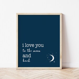 Op de afbeelding: Marineblau ingelijste print met de witte tekst "i love you to the moon and back". Een witte maan en sterren staan in de rechter benedenhoek. De lijst heeft een lichte houtkleur.