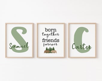 May include: Three framed prints with a green and brown color scheme. The left print features the letter "S" in green with the name "Samuel" below it. The middle print features the text "born together friends forever" with a small illustration of two bears and trees. The right print features the letter "C" in green with the name "Carter" below it.