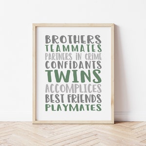 May include: A framed print with the words "Brothers, Teammates, Partners in Crime, Confidants, Twins, Accomplices, Best Friends, Playmates" in green and gray text.