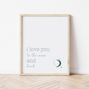Op de afbeelding: Een ingelijste print met de woorden "i love you to the moon and back" in lichtgrijze letters. Een donkerblauwe halve maan en sterren grafiek staat in de rechter benedenhoek. De lijst is van licht hout.