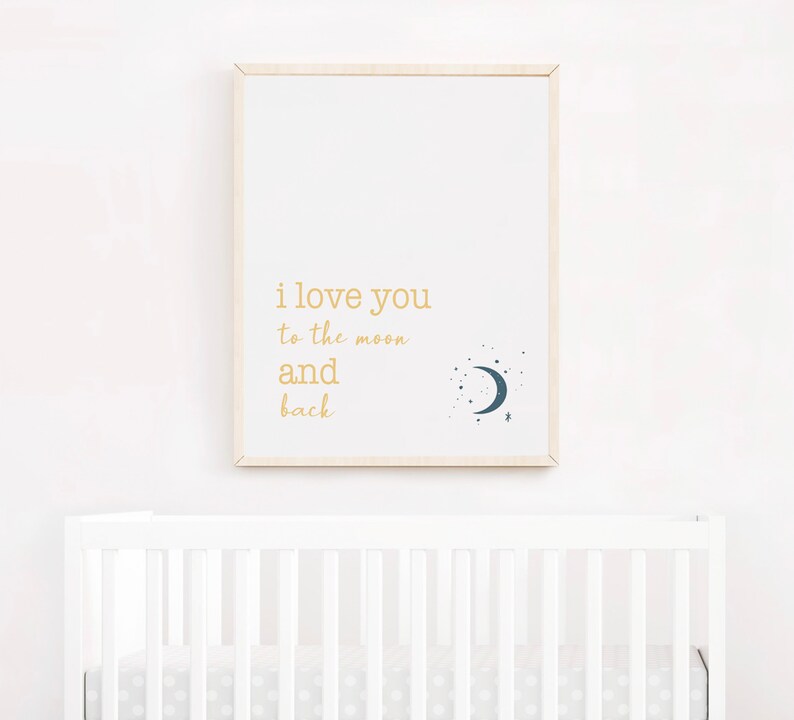 Op de afbeelding: Een ingelijste print met de woorden "i love you to the moon and back" in gouden letters. Een donkerblauwe halve maan en sterrenafbeelding staat rechts. De print hangt boven een witte wieg.