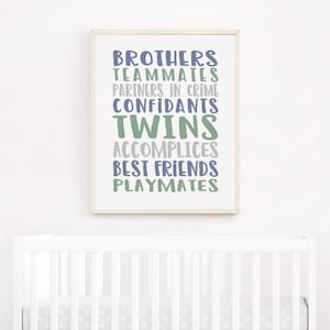 May include: A framed print with the words "Brothers, Teammates, Partners in Crime, Confidants, Twins, Accomplices, Best Friends, Playmates" in blue and green text on a white background.