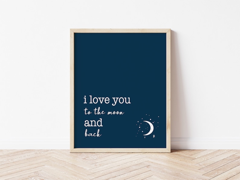 Op de afbeelding: Marineblau ingelijste print met de witte tekst "i love you to the moon and back". Een witte maan en sterren staan in de rechter benedenhoek. De lijst heeft een lichte houtkleur.