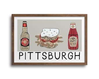 May include: A framed print with a collage of a sandwich, a bottle of beer, and a bottle of ketchup. The text "PITTSBURGH" is printed below the collage.