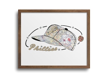 May include: A framed print of a baseball cap with a map design. The cap is in the colors of the Philadelphia Phillies, with the team's logo on the front. The text "Phillies" is written in a stylized font below the cap.