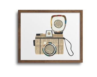 May include: A framed collage artwork of a vintage camera with a flash. The camera and flash are made of paper and have a textured, vintage look. The frame is brown wood.
