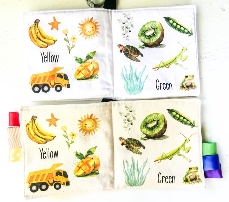 May include: A colorful fabric book for babies and toddlers with images of a yellow banana, a yellow sun, a yellow truck, a green kiwi, a green mantis, a green frog, and the words "Yellow" and "Green".
