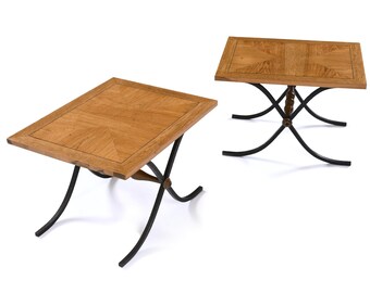 May include: Two square wooden end tables with intricate wood grain patterns on the top. The tables have black metal legs with a curved design.