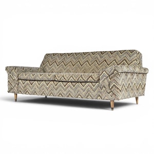 May include: A three-seat sofa upholstered in a textured fabric featuring a multi-colored chevron pattern in shades of brown, tan, black, and cream. The sofa has a straight back, two rolled arms, and is supported by four tapered wooden legs.