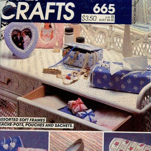 Pode incluir: Imagem de um livro de padrões McCall's Crafts, apresentando vários projetos de artesanato. A imagem mostra molduras macias, cache-pots, bolsas e saquinhos. A paleta de cores inclui azul, rosa e branco, com padrões florais e elementos decorativos.