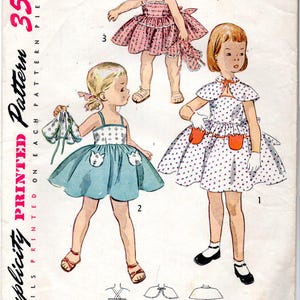 May include: Vintage Simplicity pattern featuring illustrations of three little girls in dresses. The pattern includes a pink polka-dot dress, a blue dress with cat pockets, and a white polka-dot dress with orange pockets. The pattern is for size 2.