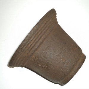 Op de afbeelding: Een bruine gietijzeren mortier met een ruwe textuur en een licht uitlopende rand.