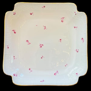 Op de afbeelding: Een witte vierkante serveerschaal met een gouden rand en een delicaat roze bloemenpatroon.