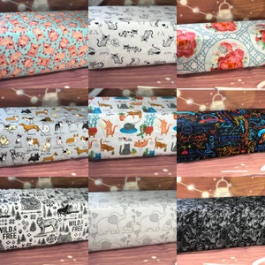 May include: A collection of ten fabric swatches featuring various patterns. The patterns include pink pigs on a light blue background, black and white cats on a white background, red and white flowers on a light blue background, black and white dogs on a light blue background, cats and plants on a white background, black and white text on a black background, black and white trees on a white background, gray elephants and hearts on a white background, and a black and white abstract pattern on a gray background.
