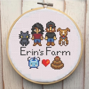 Könnte beinhalten: Stickbild in einem Stickrahmen mit einer dreiköpfigen Familie, einer Katze, einem Hund und landwirtschaftlichen Motiven. Der Text "Erin's Farm" ist unter der Familie gestickt.