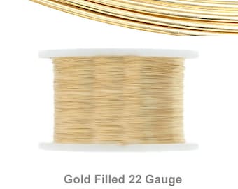 May include: A spool of gold filled 22 gauge half hard round wire. The wire is wound tightly around a white spool.