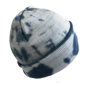 May include: A blue and white tie-dye beanie hat. The hat is made of a soft, knitted fabric and has a fold-over cuff.