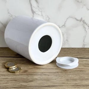 a white vase sitting on top of a wooden table