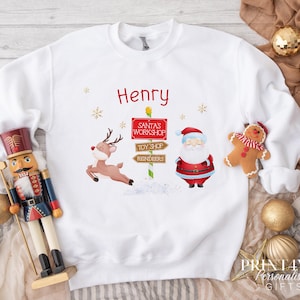 Personalised Christmas Jumper For Children.  White Cotton Sweatshirt - Santa and Reindeer Workshop Northpole Sign Graphics