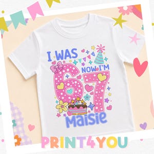 A white t-shirt with a colorful design and text, including the number "67" and the text "I WAS NOW I'M MAISIE".