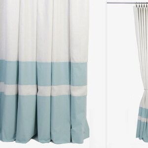 May include: White curtains with a light blue band at the bottom. The curtains have a white stripe in the middle of the blue band.