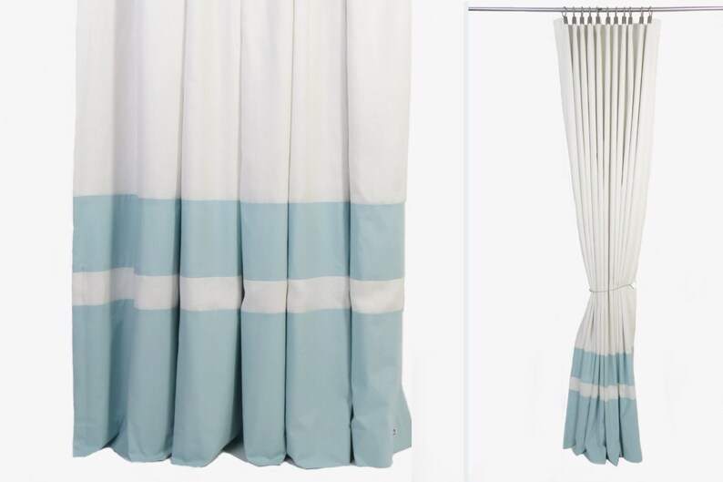 May include: White curtains with a light blue band at the bottom. The curtains have a white stripe in the middle of the blue band.