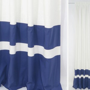 May include: White shower curtain with blue horizontal stripes. The curtain has a simple design with alternating white and blue stripes.