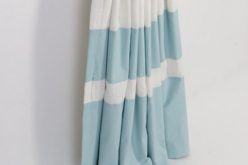 May include: A pair of blue and white striped curtains with a gathered look. The curtains are made of a soft, lightweight fabric.