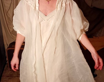May include: A white sheer robe with a lace trim and a matching slip underneath. The robe has a gathered neckline and long sleeves.