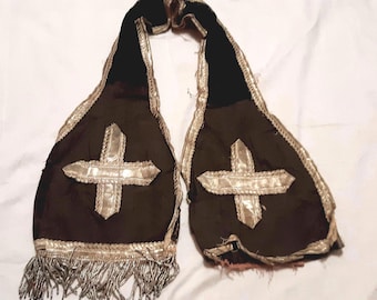 May include: A black velvet sash with silver trim and two silver crosses. The sash has fringe on the bottom.