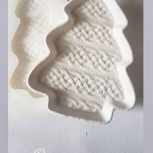 May include: White ceramic mould shaped like a Christmas tree with a knitted pattern. The mould is 17.5 inches by 22 inches.