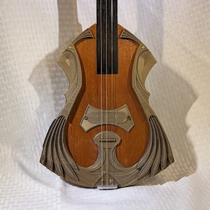 May include: A unique, intricately carved wooden guitar with a brown finish and silver accents. The guitar has a distinctive shape with a large, ornate sound hole and a decorative design on the body.