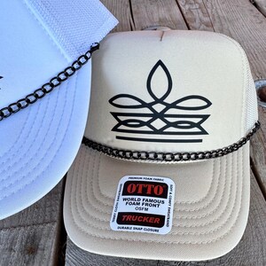 Tan cowgirl mesh trucker hat with black boot stitch graphic and chain