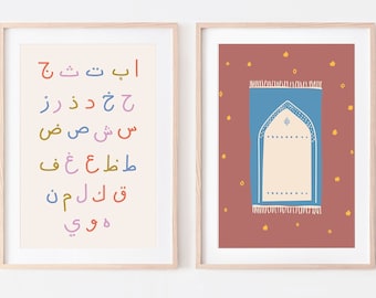 May include: Two framed prints with a light beige background. The print on the left features the Arabic alphabet in colorful letters. The print on the right features a stylized illustration of a prayer rug with a blue border and a cream-colored interior. The background of the prayer rug print is a deep red with small yellow stars.