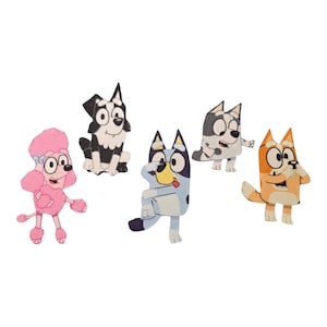 May include: Five colorful fabric appliques featuring cartoon dog characters. The appliques include a pink poodle, a black and white dog, a blue and white dog, a gray and white dog, and an orange and white dog. Each applique has a unique design and expression.