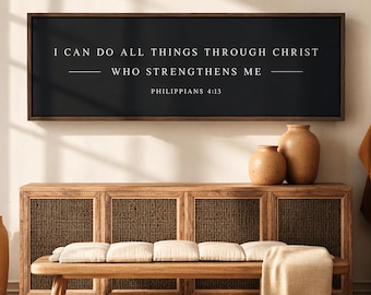 May include: A rectangular wall sign with a dark charcoal background and a thin brown frame. The white text reads: I CAN DO ALL THINGS THROUGH CHRIST WHO STRENGTHENS ME, followed by the citation PHILIPPIANS 4:13 in a clean, sans-serif font.