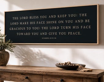 Puede incluir: Un letrero de pared rectangular con fondo negro y marco de madera clara. El texto en letras doradas dice: THE LORD BLESS YOU AND KEEP YOU; THE LORD MAKE HIS FACE SHINE ON YOU AND BE GRACIOUS TO YOU; THE LORD TURN HIS FACE TOWARD YOU AND GIVE YOU PEACE. NUMBERS 6:24-26.
