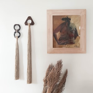 Decorative wall hanging set of two, made of wood and hemp twine. Comes in two different shapes: triangle and double circle.