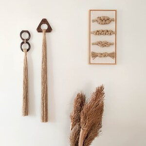 Decorative wall hanging set of two, made of wood and hemp twine. Comes in two different shapes: triangle and double circle.